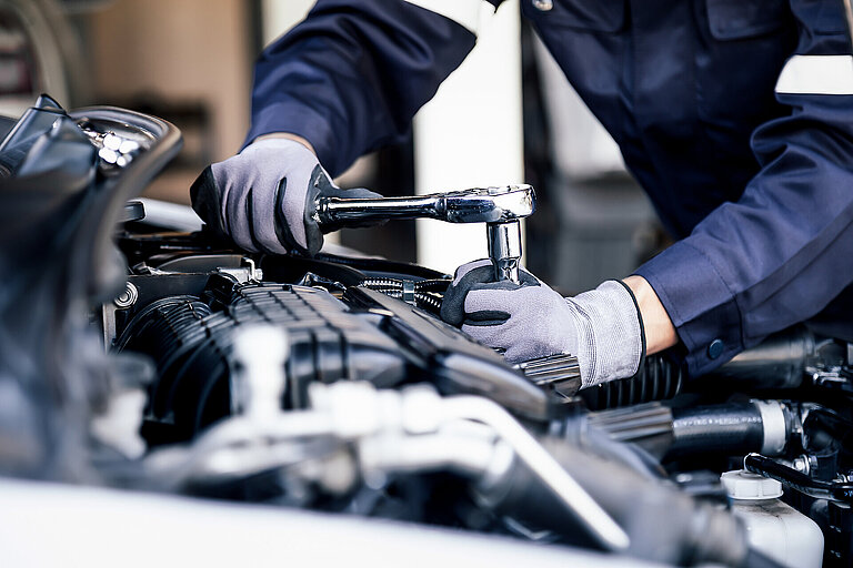 Professional mechanic working on the engine of the car in the ga