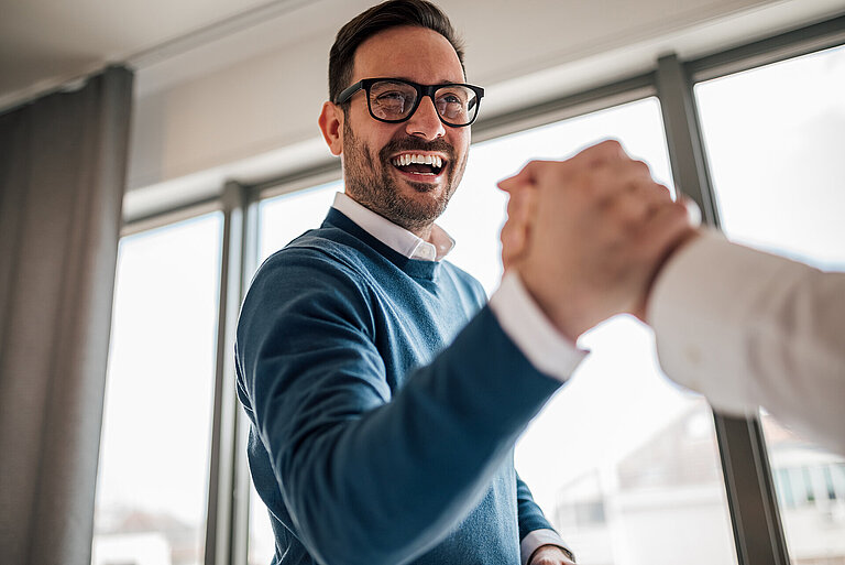 Excited young adult businessman, greeting a new member of his te